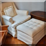 F58. White upholstered chair and ottoman. 